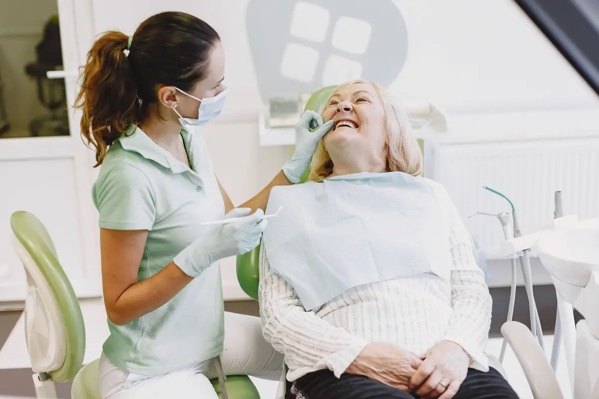 Dentist treating a smiling older patient in a bright clinic