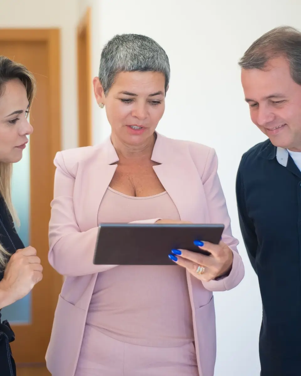 Estate agent showing a couple property details on a tablet