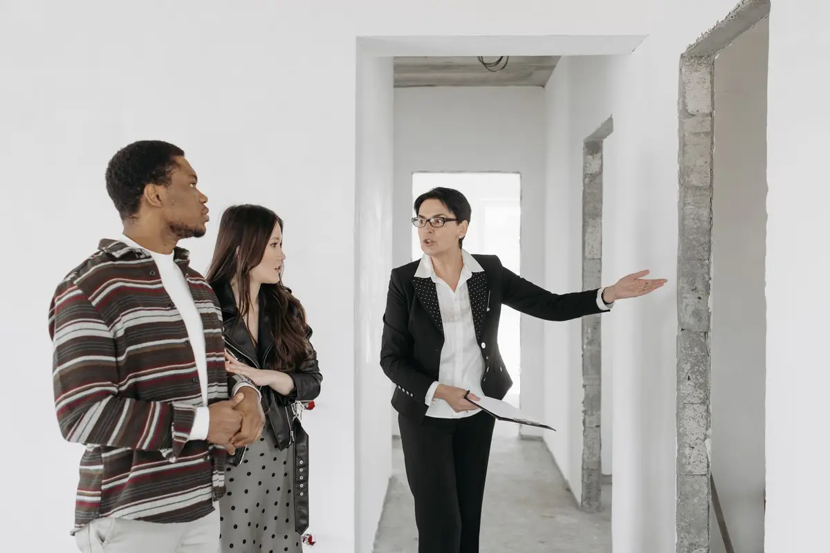 Estate agent showing a couple around a newly finished home